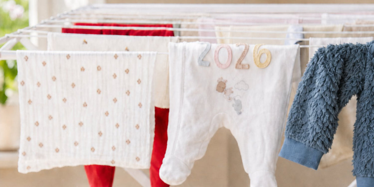 Droogrek met babykleding, waaronder een romper met 2026