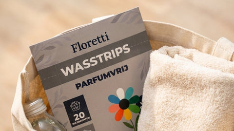 Floretti wasstrips met een opgerolde handdoek en een flesje in een katoenen tas, klaar voor onderweg