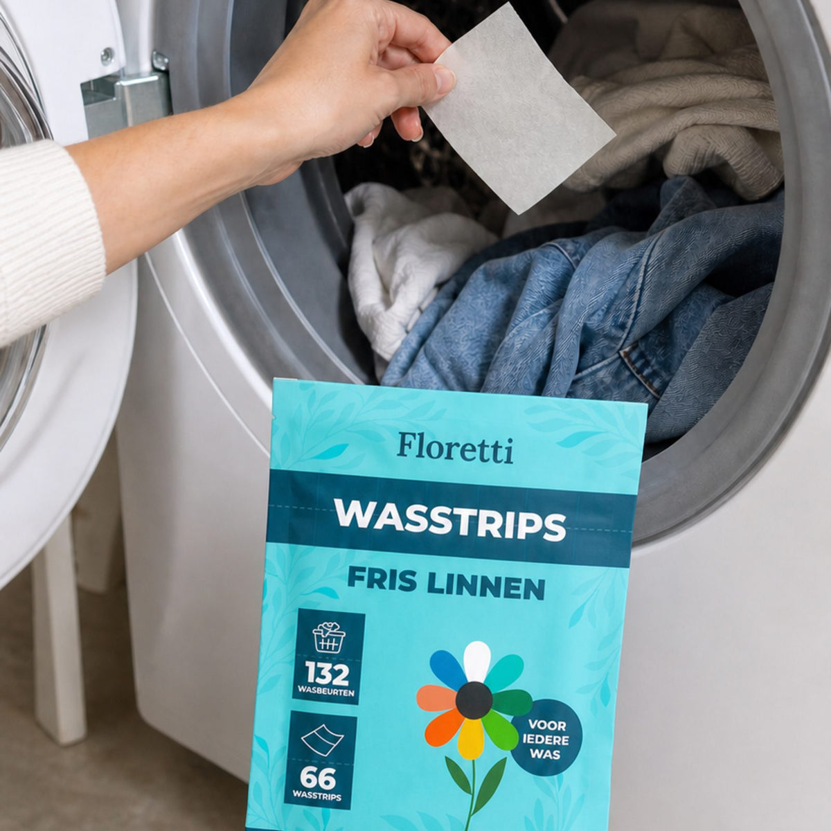 Hand legt een Floretti wasstrip in de trommel van de wasmachine