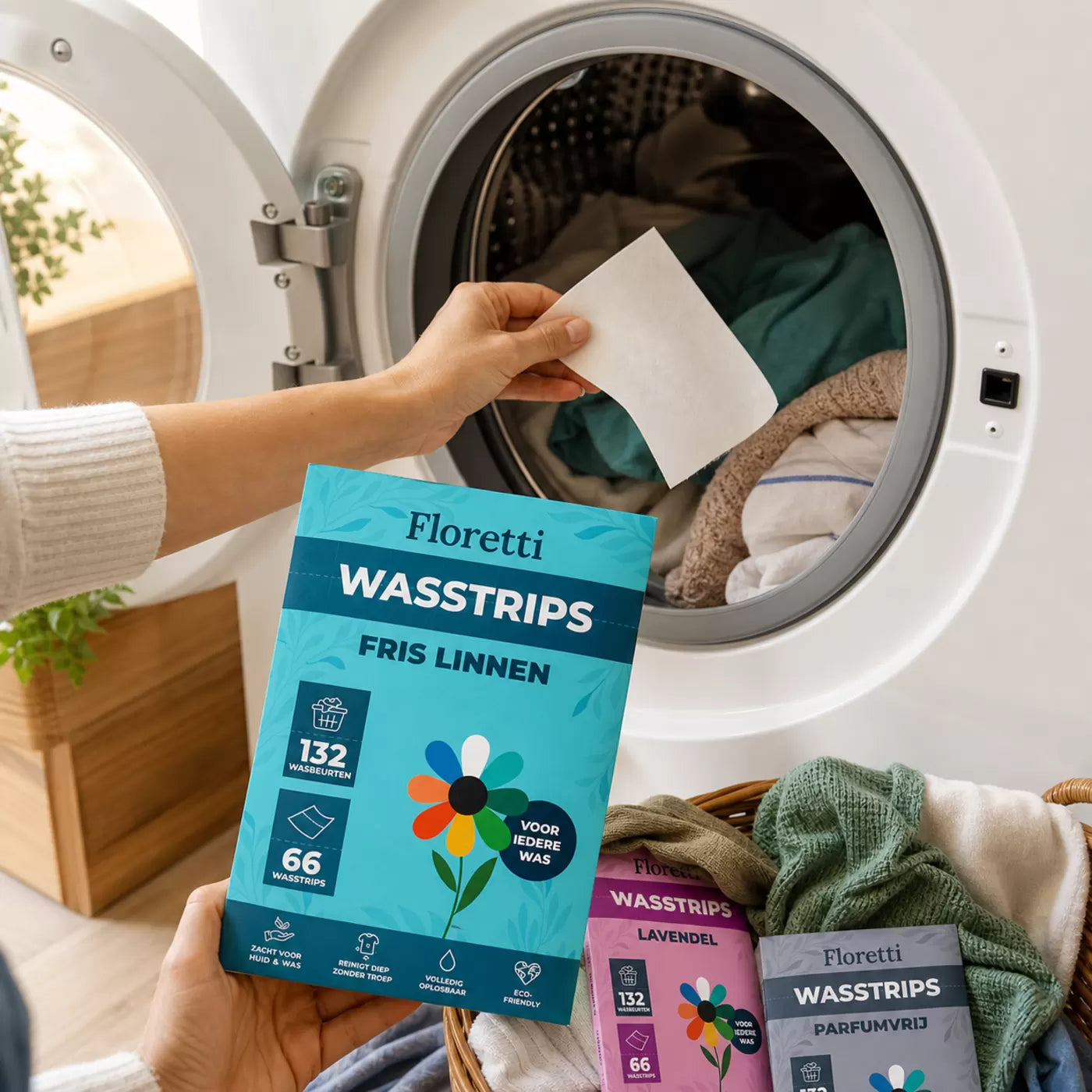 Hand legt een Floretti wasstrip in de trommel, met het pak Fris Linnen op de voorgrond